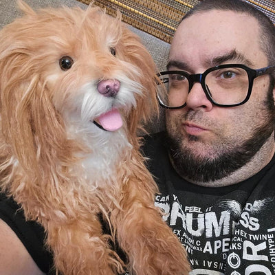 Customer holding the custom stuffed animal of her cream curly-coated dog