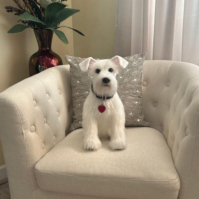 Custom stuffed animal of a small white dog sitting on a cream armchair