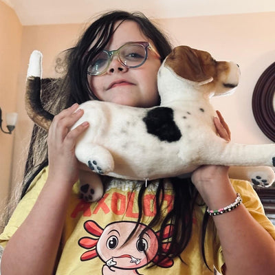 Girl holding a large, life-size custom stuffed animal of her brown and white dog