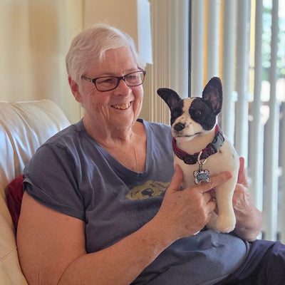 Customer holding the stuffed animal replica made from photos of her dog