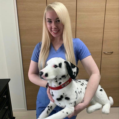 Customer kneeling beside a large stuffed animal replica of her spotted dog